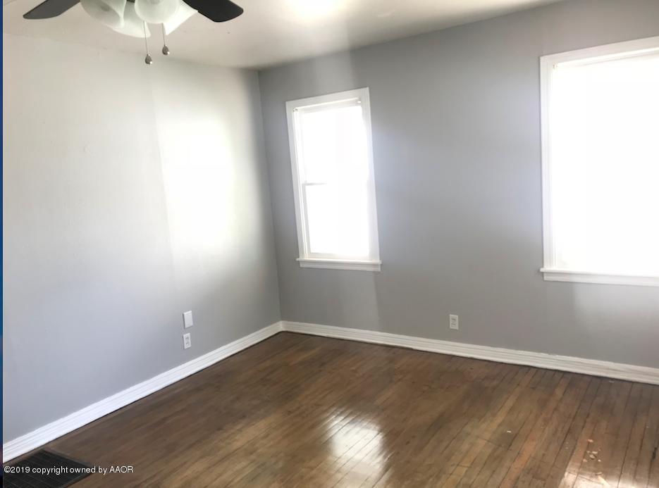 4110 South Lipscomb Street Amarillo, TX 79110 - Photo 3 of 13 an empty room with wooden floor and windows