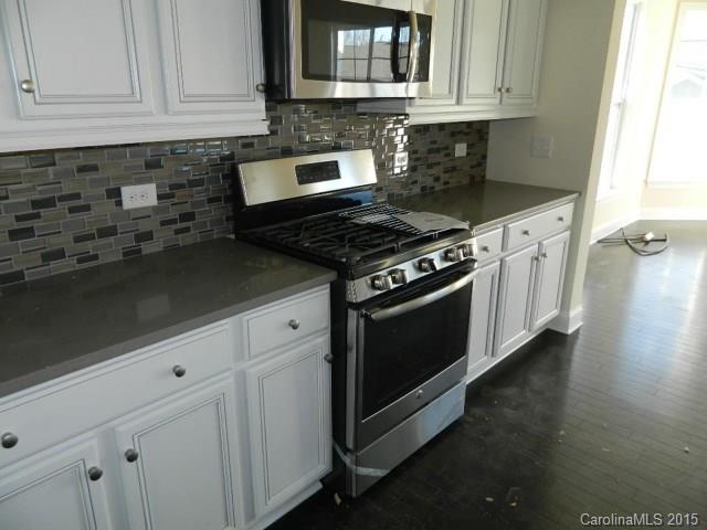729 Falcon Ridge, Unit HKC109 Fort Mill, SC 29708 - Photo 5 of 12 a kitchen with granite countertop white cabinets and appliances