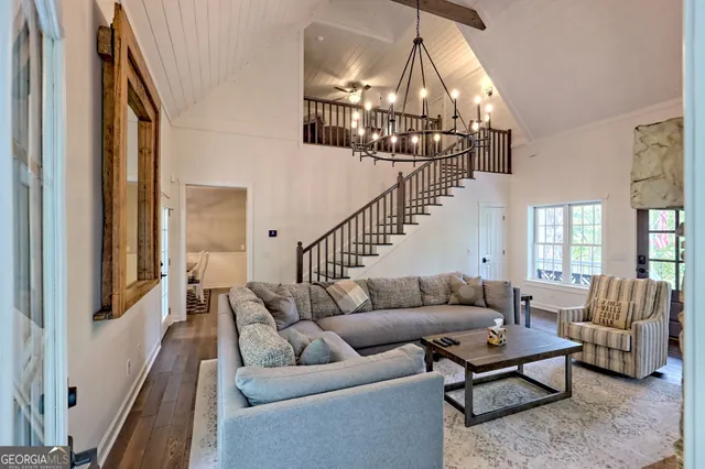 a kitchen with stainless steel appliances a stove a refrigerator a sink dishwasher a dining table and chairs with wooden floor