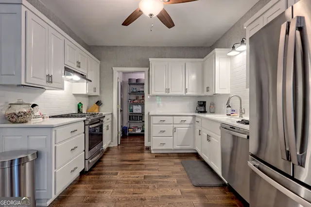 a bathroom with a granite countertop sink vanity mirror and toilet