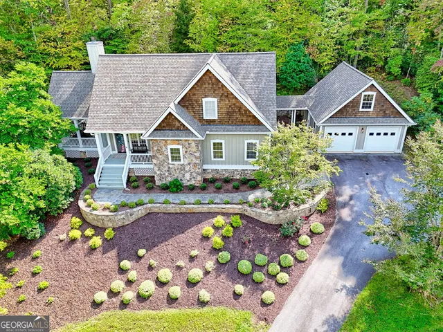 a front view of a house with a garden and trees