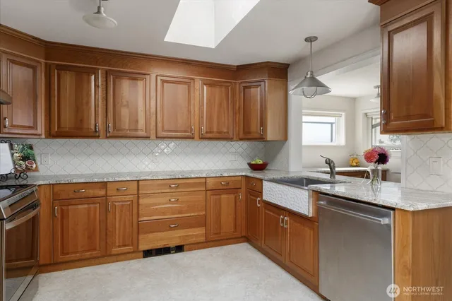 a kitchen with granite countertop a sink stainless steel appliances and cabinets