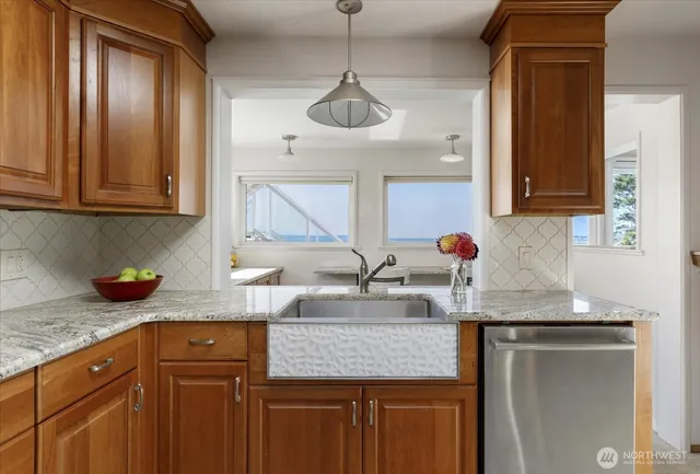 a kitchen with stainless steel appliances granite countertop a sink and a wooden cabinets