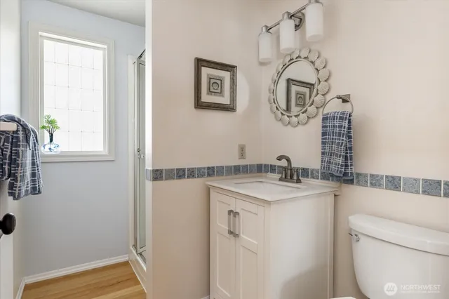 a bathroom with a granite countertop sink a toilet and with mirror