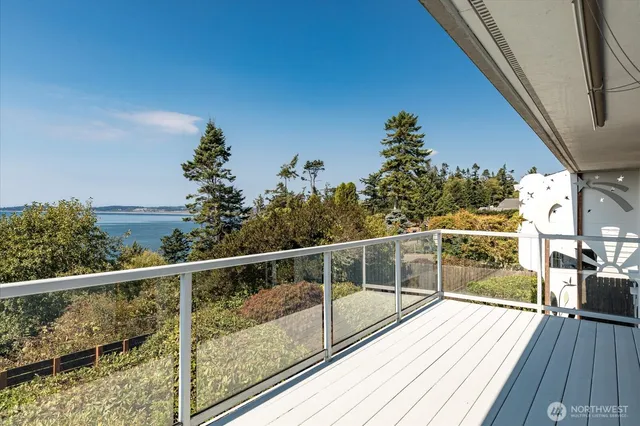 a view of a balcony with wooden floor and iron fence