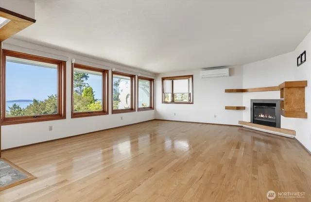 wooden floor fireplace and windows in an empty room