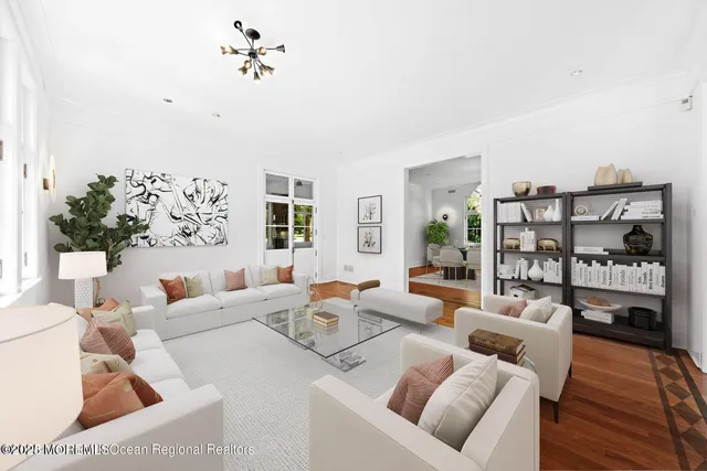 a dining room with chandelier and wooden floor