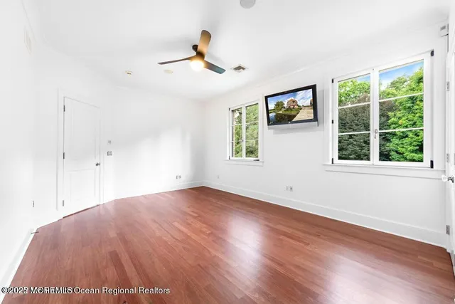 a view of a hallway with wooden floor and a large window