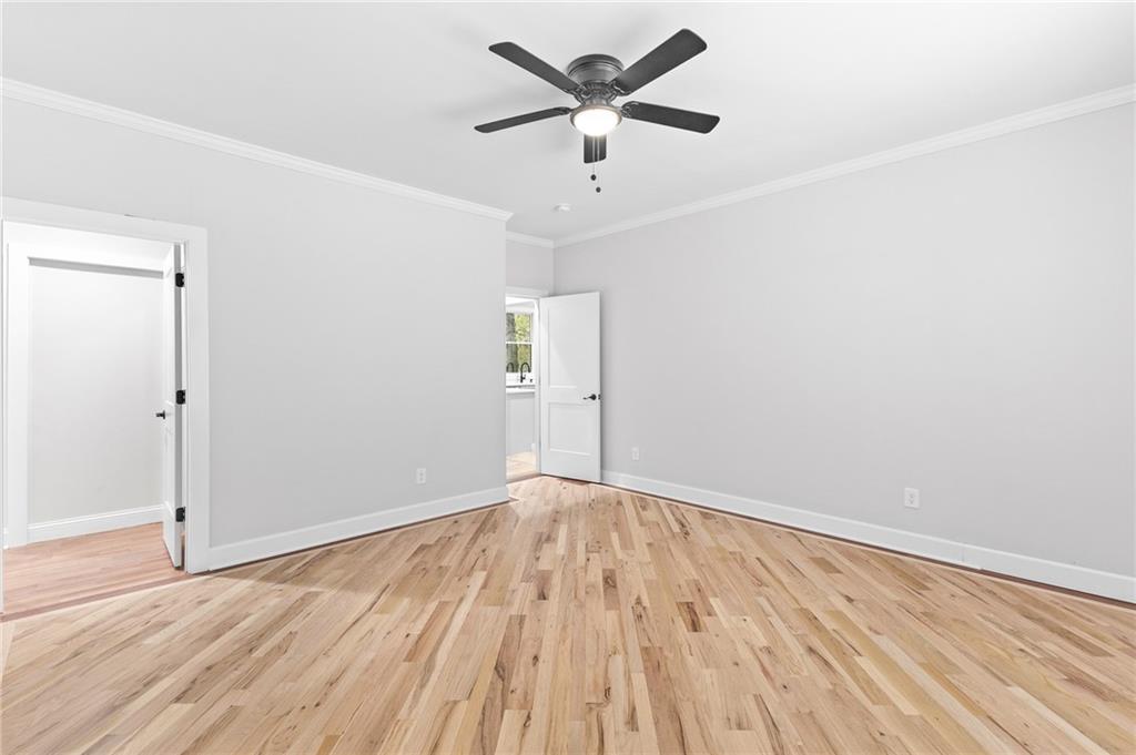 1713 Cagle Court Lawrenceville, GA 30045 - Photo 19 of 50 an empty room with wooden floor and a ceiling fan