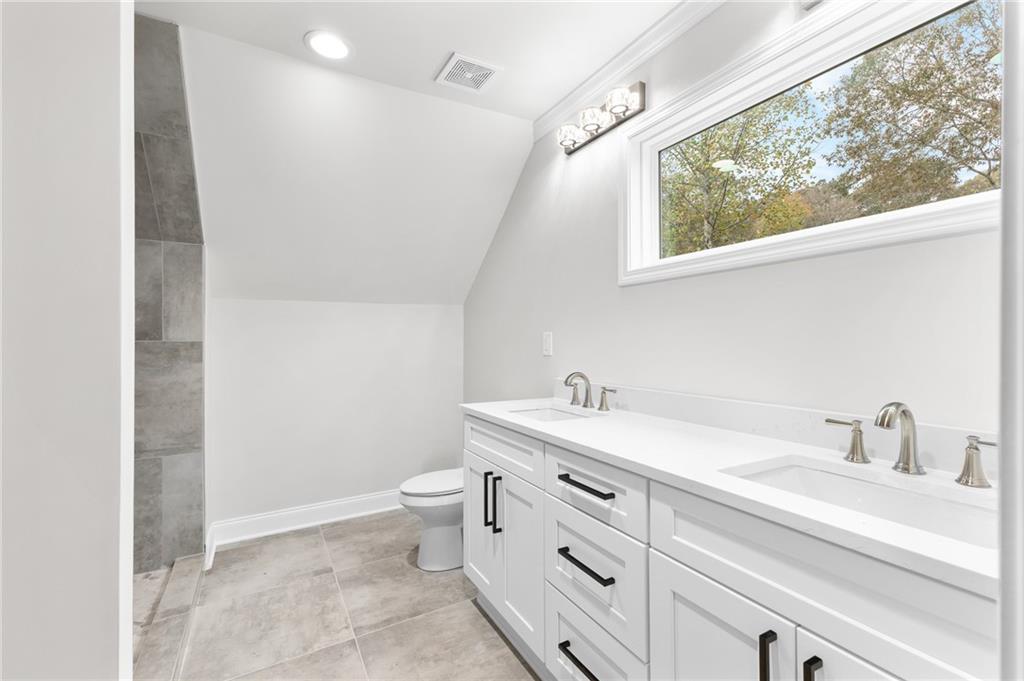 1713 Cagle Court Lawrenceville, GA 30045 - Photo 27 of 50 a bathroom with a granite countertop sink mirror vanity and toilet