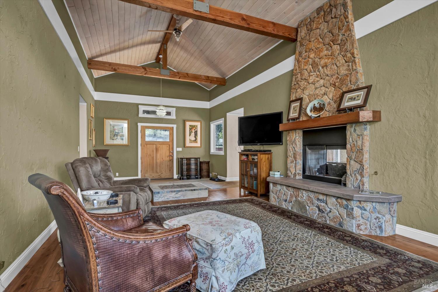 1900 Stagecoach Canyon Road Pope Valley, CA 94567 - Photo 6 of 70 a living room with furniture a flat screen tv and a fireplace