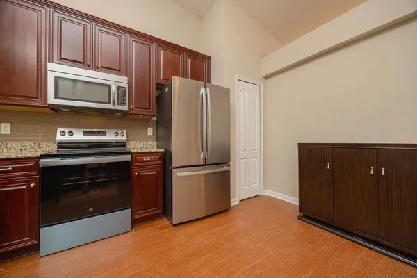 a kitchen with stainless steel appliances granite countertop a refrigerator stove and microwave