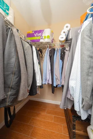 a view of walk in closet with clothes and shoes