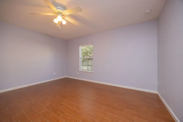 an empty room with a window and a fan