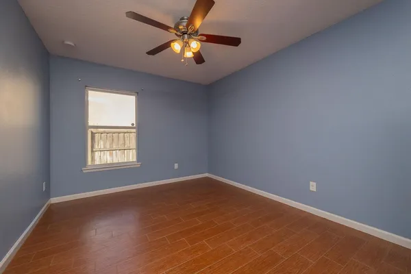 an empty room with a window and a fan