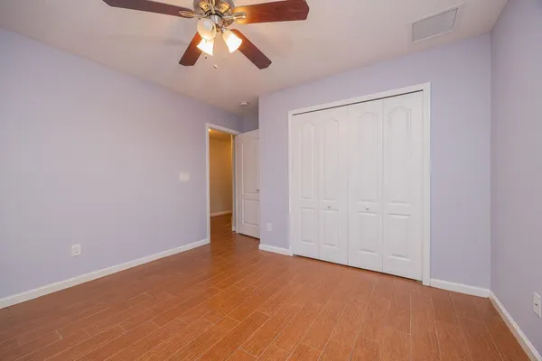 an empty room with closet and a chandelier fan