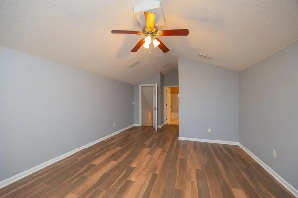 a view of empty room with wooden floor