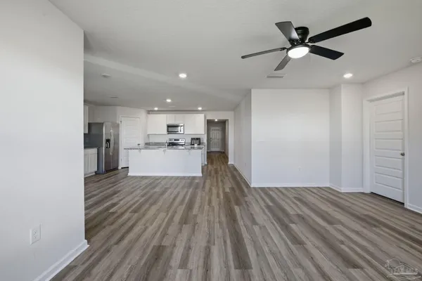 a view of a kitchen with wooden floor a sink and a refrigerator
