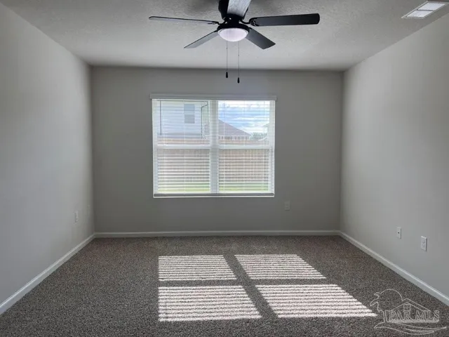 an empty room with a window and a ceiling fan