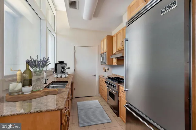 a kitchen with stainless steel appliances granite countertop a refrigerator and a stove