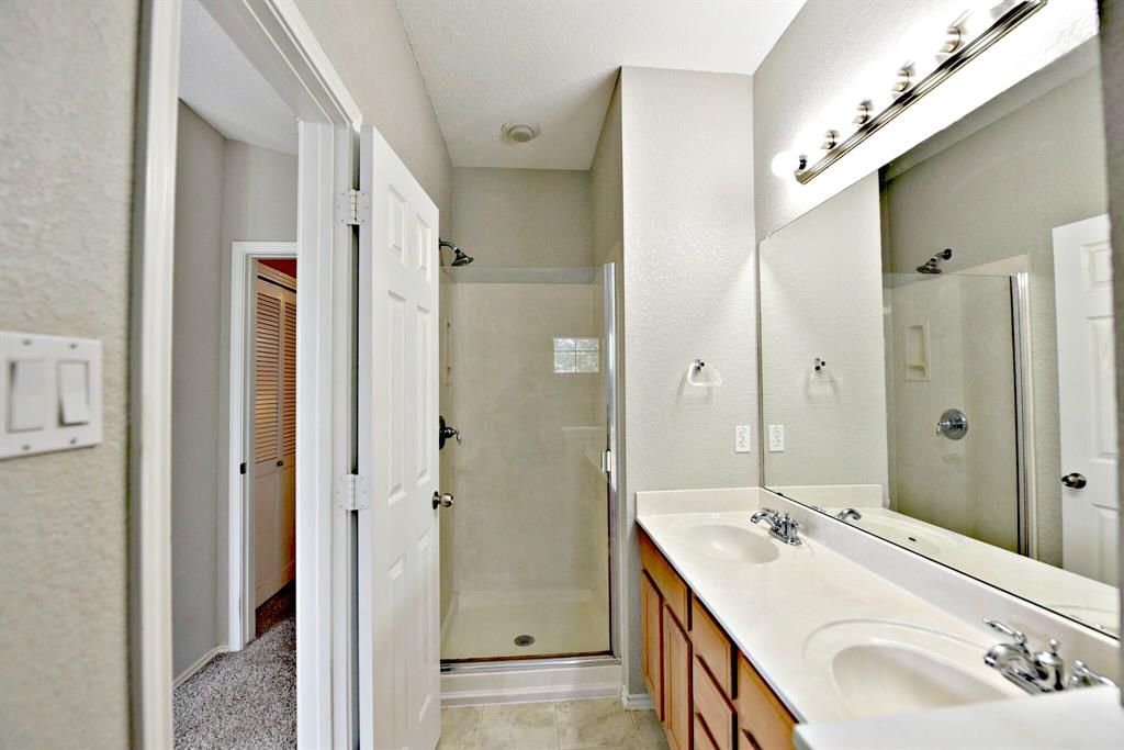 14815 Avery Ranch Boulevard, Unit 702 Austin, TX 78717 - Photo 13 of 19 Full bathroom with double vanity, a stall shower, and a sink