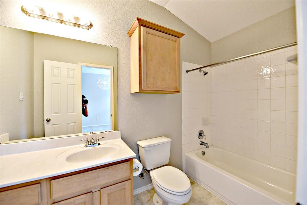 14815 Avery Ranch Boulevard, Unit 702 Austin, TX 78717 - Photo 16 of 19 Bathroom with bathing tub / shower combination, vanity, vaulted ceiling, and toilet