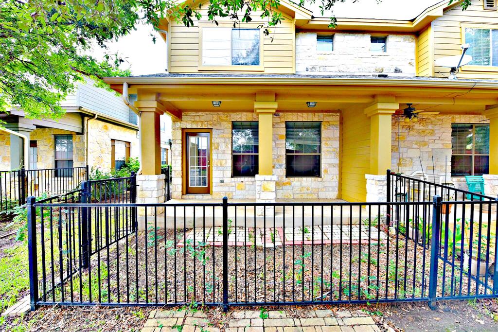 14815 Avery Ranch Boulevard, Unit 702 Austin, TX 78717 - Photo 18 of 19 View of front of property featuring a fenced front yard, stone siding, a ceiling fan, and covered porch