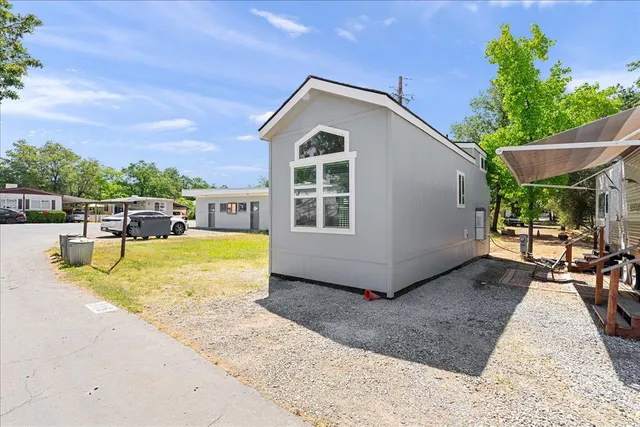 a view of a house with backyard and sitting area