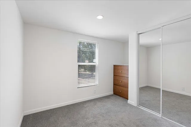 an empty room with windows and closet