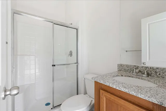 a bathroom with a granite countertop sink toilet and shower