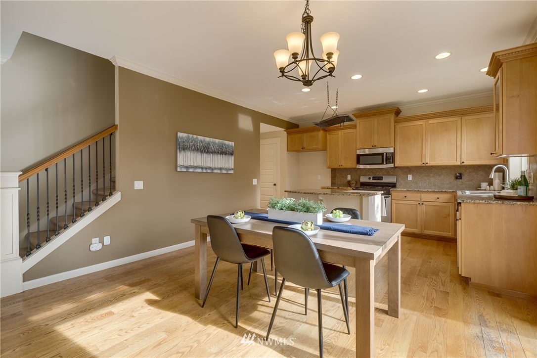 1532 170th Street Southeast Bothell, WA 98012 - Photo 12 of 39 a view of a dining room with furniture a kitchen and chandelier