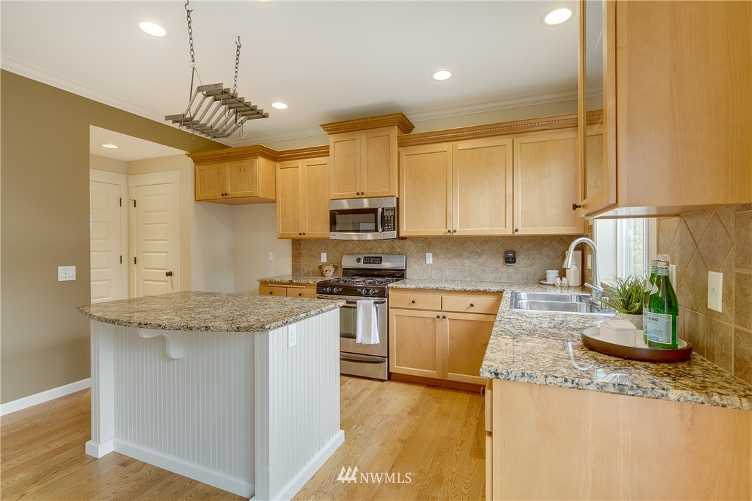 1532 170th Street Southeast Bothell, WA 98012 - Photo 15 of 39 a kitchen with stainless steel appliances granite countertop a sink a stove top oven a counter space and cabinets