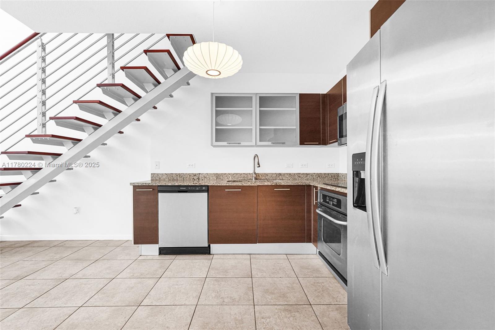 41 Southeast 5th Street, Unit 406 Miami, FL 33131 - Photo 11 of 68 a kitchen with stainless steel appliances granite countertop a sink and a stove