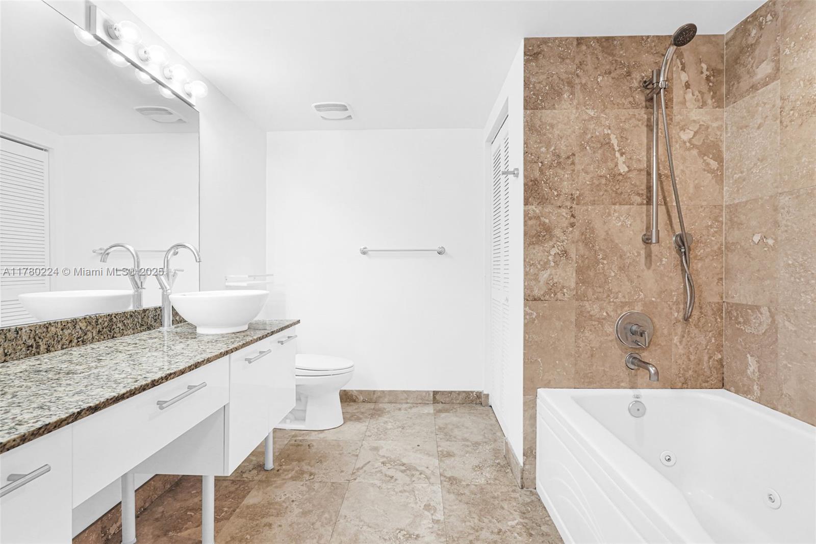 41 Southeast 5th Street, Unit 406 Miami, FL 33131 - Photo 25 of 68 a bathroom with a granite countertop sink a toilet and bathtub