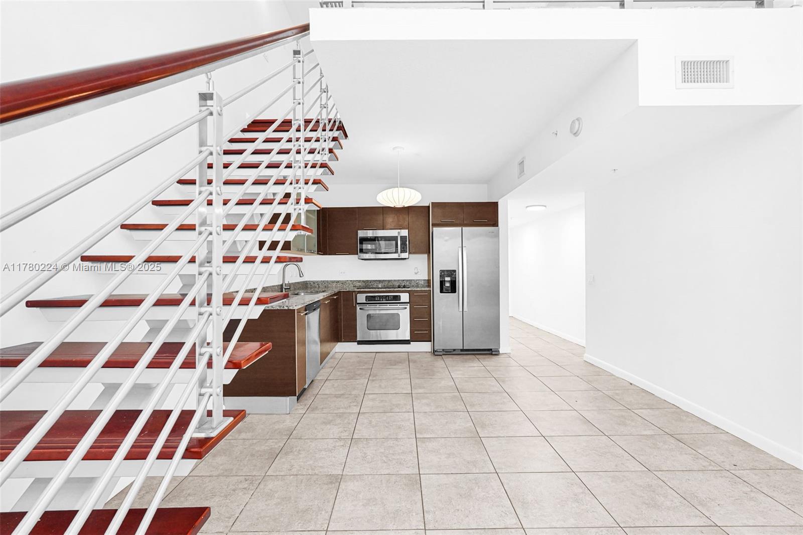 41 Southeast 5th Street, Unit 406 Miami, FL 33131 - Photo 40 of 68 a kitchen with granite countertop stainless steel appliances a sink and a counter top space