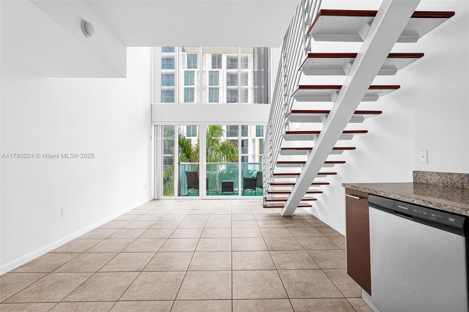 41 Southeast 5th Street, Unit 406 Miami, FL 33131 - Photo 5 of 68 a view of an empty room with stairs and furniture