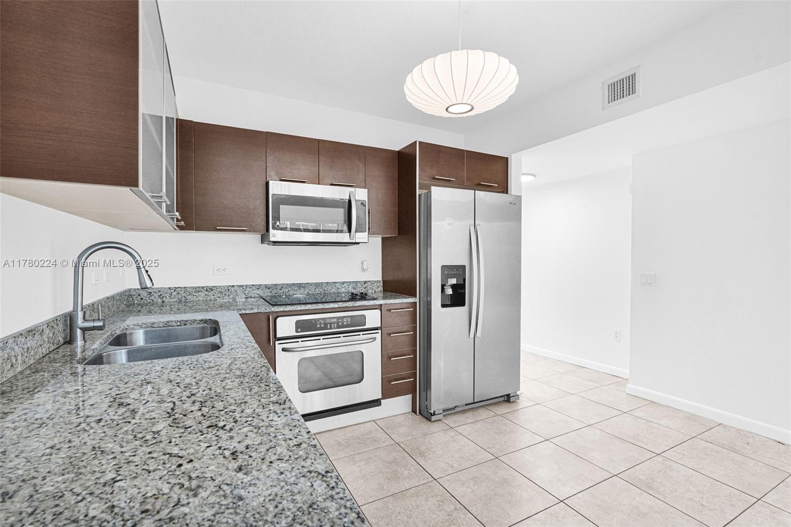 41 Southeast 5th Street, Unit 406 Miami, FL 33131 - Photo 6 of 68 a kitchen with granite countertop a refrigerator and a sink