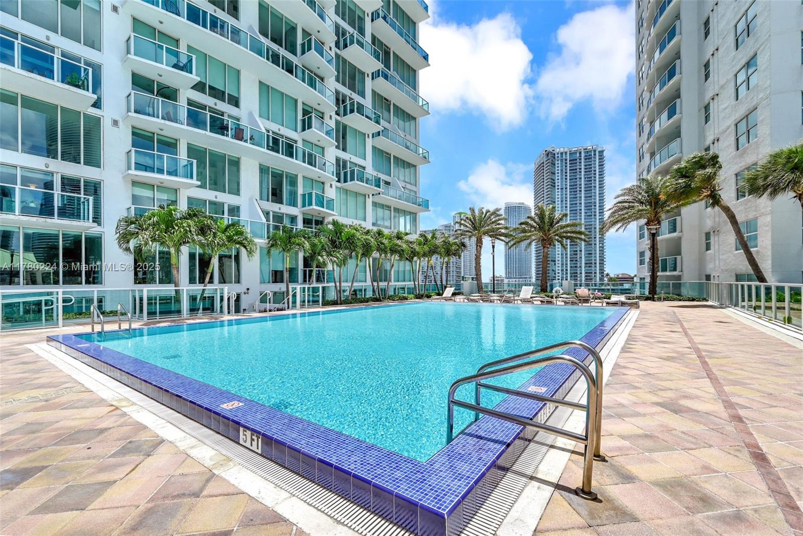 41 Southeast 5th Street, Unit 406 Miami, FL 33131 - Photo 61 of 68 a view of a swimming pool with a lounge chairs