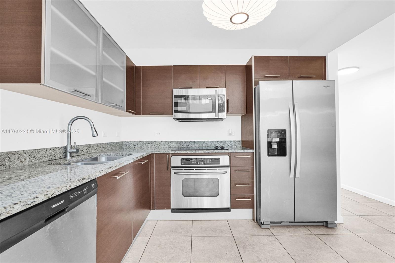 41 Southeast 5th Street, Unit 406 Miami, FL 33131 - Photo 7 of 68 a kitchen with stainless steel appliances granite countertop a refrigerator and a sink
