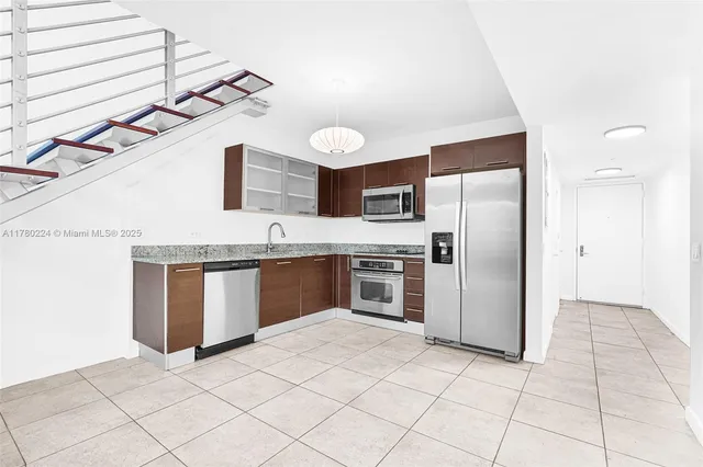 a kitchen with stainless steel appliances granite countertop a sink and a stove