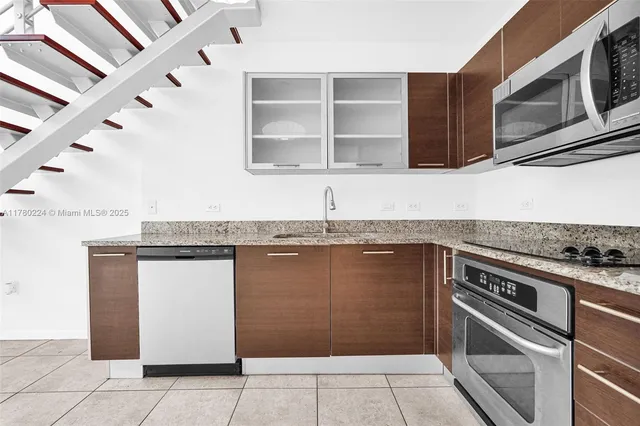 a view of a kitchen with granite countertop a sink and a stove