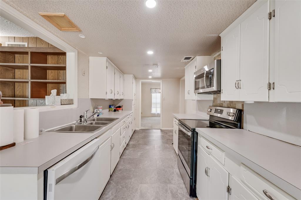 102 South Royal Oak Drive Duncanville, TX 75116 - Photo 11 of 19 a large white kitchen with stainless steel appliances