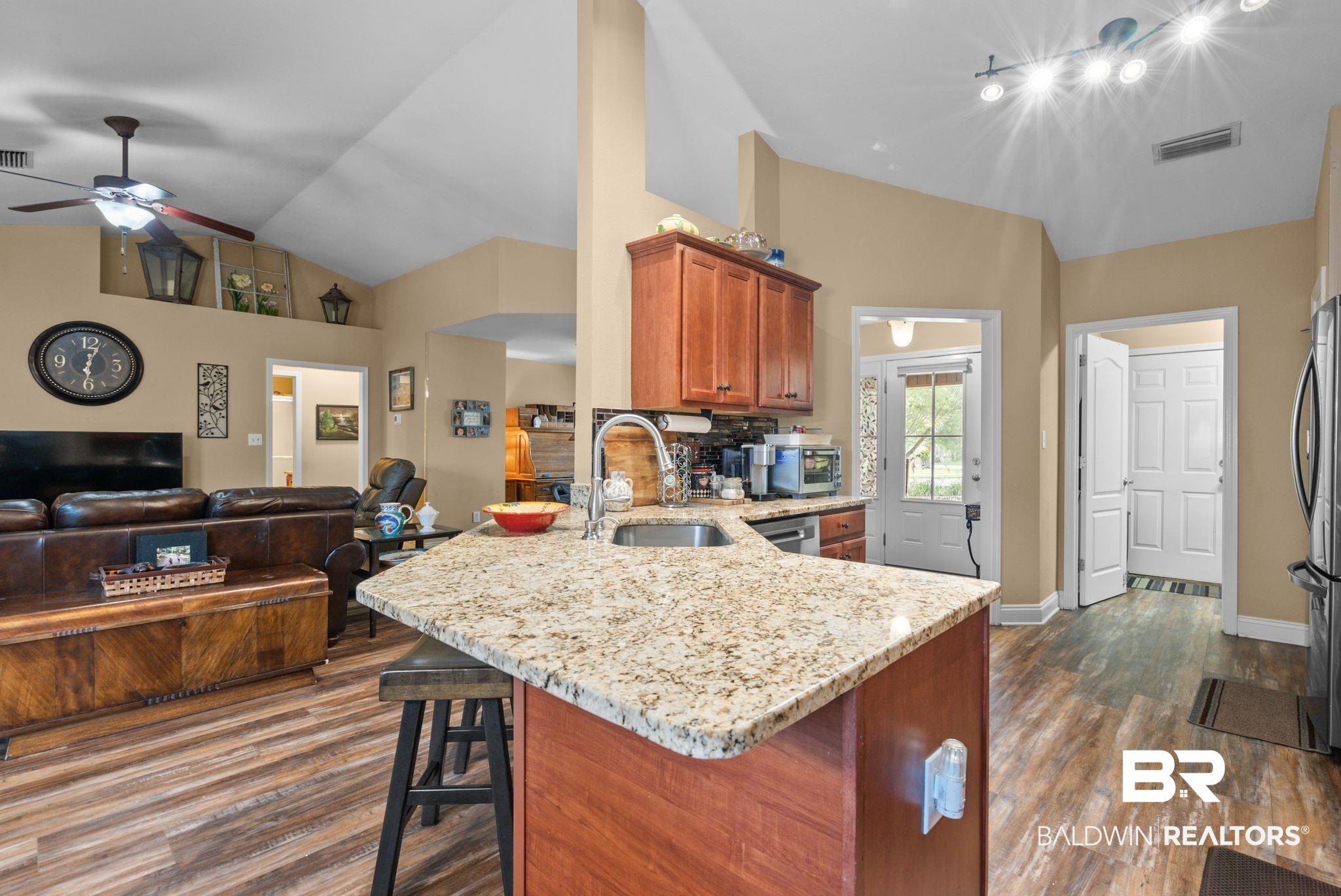 562 Vestige Mews Foley, AL 36535 - Photo 19 of 54 Kitchen island with granite countertop and undermount sink, complemented by wood-finish flooring