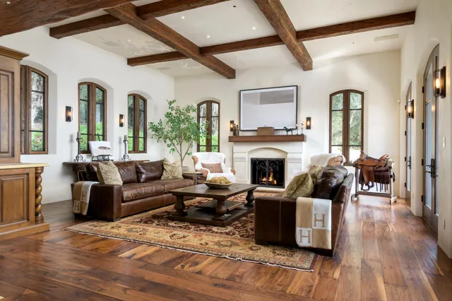 a living room with furniture fireplace and wooden floor