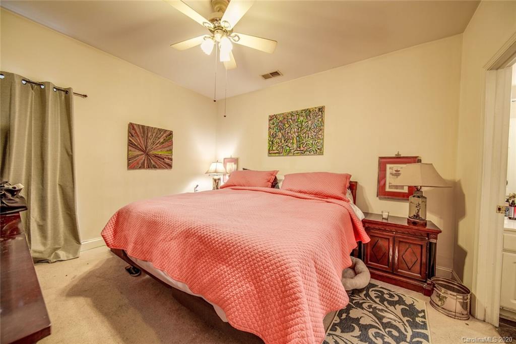 917 Shearer Street, Unit 7 Davidson, NC 28036 - Photo 17 of 31 a bedroom with a bed and a chandelier