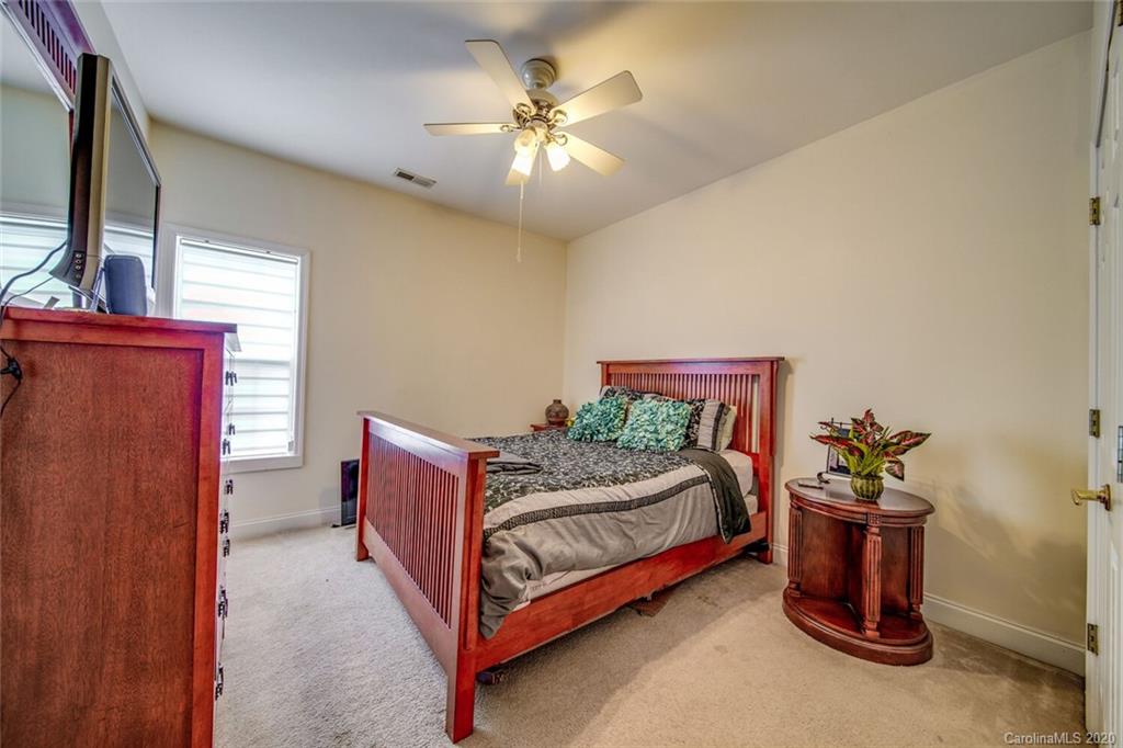 917 Shearer Street, Unit 7 Davidson, NC 28036 - Photo 26 of 31 a bed room with a bed and a chandelier