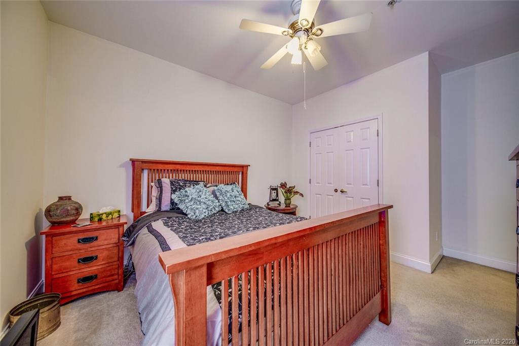 917 Shearer Street, Unit 7 Davidson, NC 28036 - Photo 27 of 31 a bedroom with a bed and a chandelier