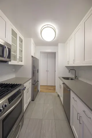 a kitchen with stainless steel appliances granite countertop a stove a sink and a refrigerator