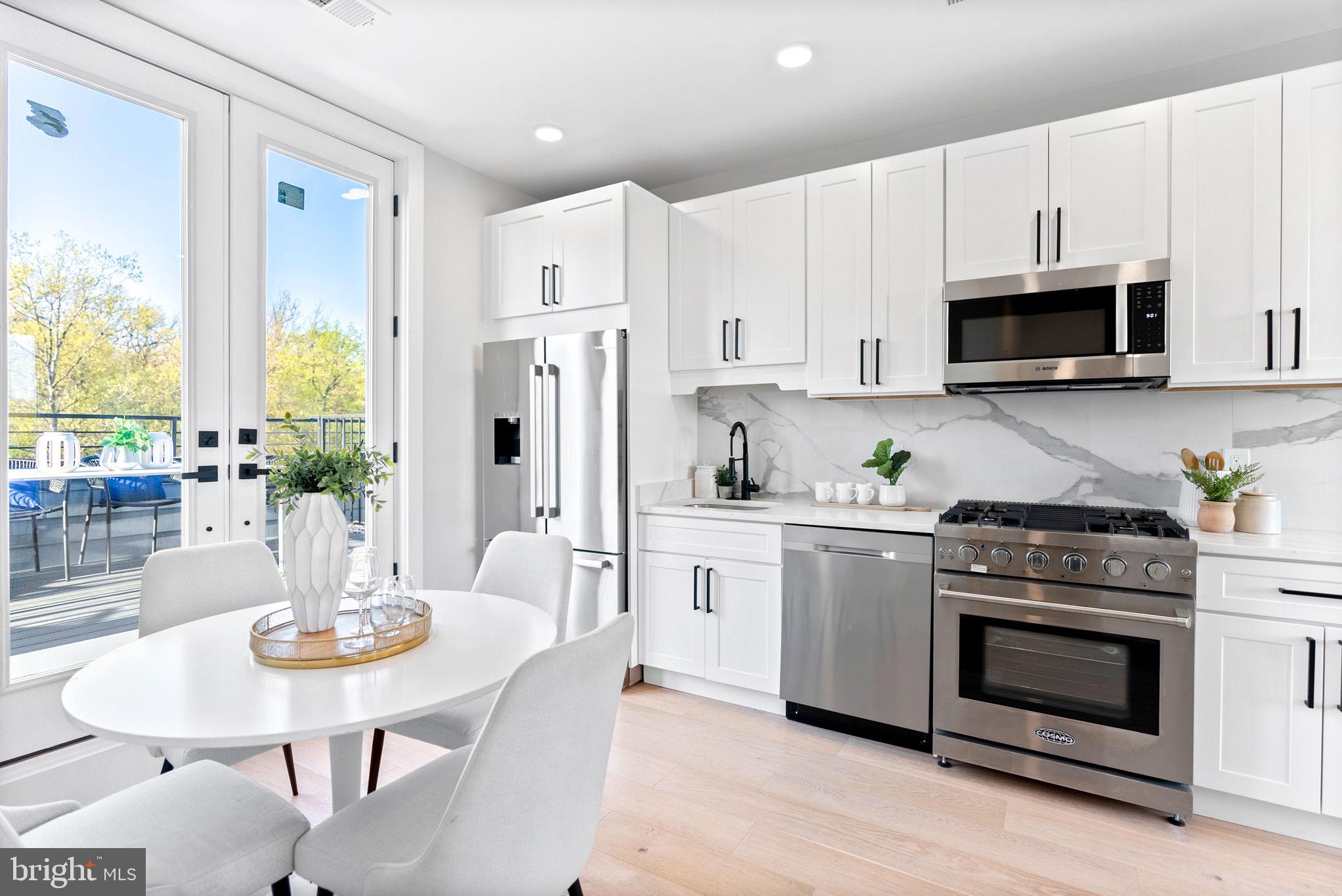 2019 M Street Northeast, Unit PH9 Washington, DC 20002 - Photo 15 of 34 a kitchen with stainless steel appliances a white table and chairs