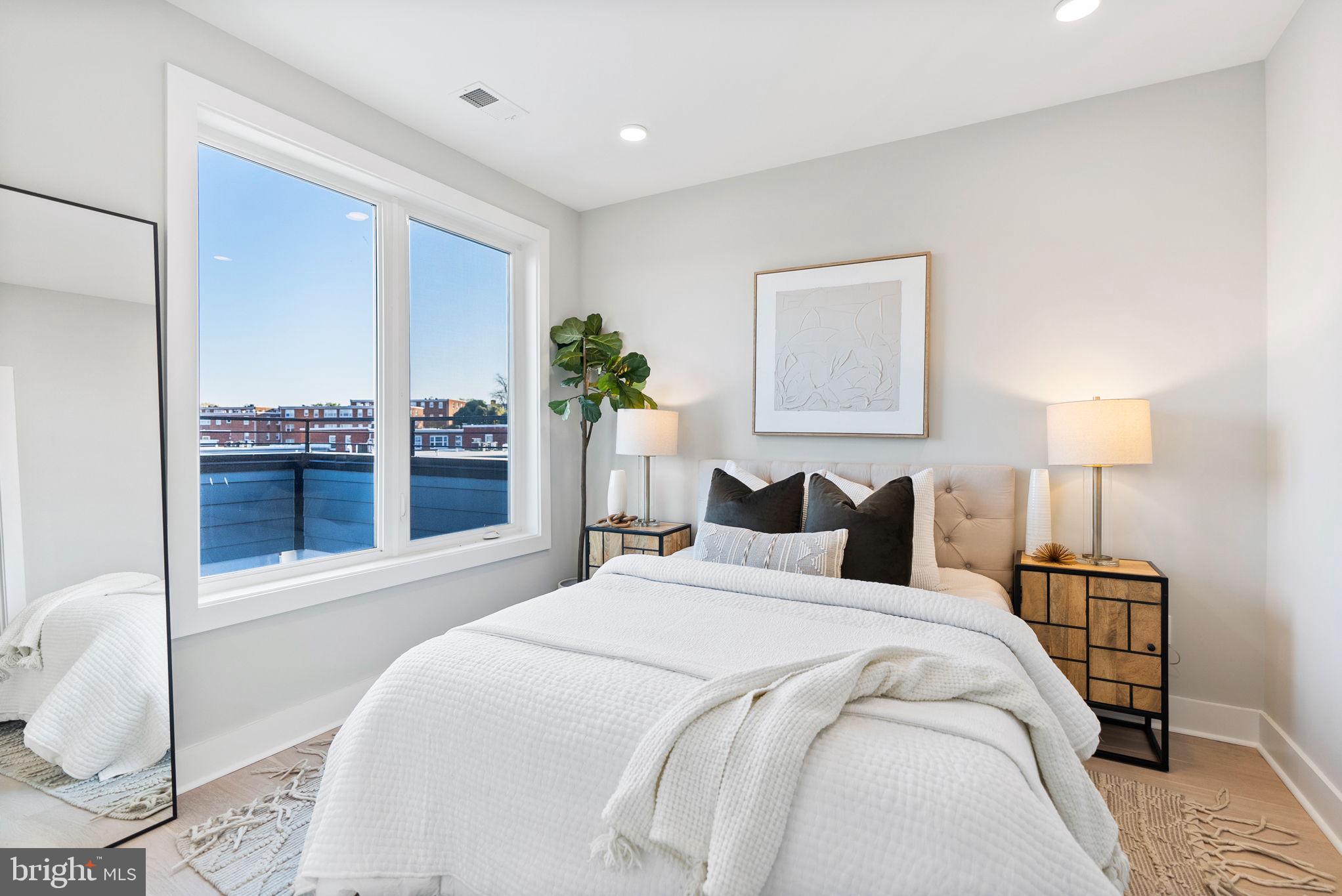 2019 M Street Northeast, Unit PH9 Washington, DC 20002 - Photo 21 of 34 a bedroom with a bed and a lamp on table